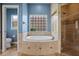 The bright bathroom features a soaking tub under a glass block window and a tiled walk-in shower at 2256 Kettle Dr, Orlando, FL 32835