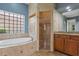 The bathroom has a soaking tub under a glass block window and a tiled walk-in shower with a glass door at 2256 Kettle Dr, Orlando, FL 32835