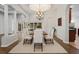 Formal dining area features wood table with white chairs, chandelier, and wood floors at 2256 Kettle Dr, Orlando, FL 32835