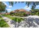 Well-manicured front yard of a beautiful house with a tile roof, lush greenery, and mature trees at 2256 Kettle Dr, Orlando, FL 32835