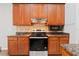 A full view of the kitchen featuring wood cabinets, granite countertops, tile backsplash and stainless steel appliances at 2256 Kettle Dr, Orlando, FL 32835