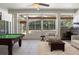 Spacious living area boasting a pool table, wet bar, and comfortable seating with views of the outdoor pool area at 2256 Kettle Dr, Orlando, FL 32835