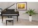 Grand piano with bench situated next to artwork and green potted plant enhances the room's elegance at 2256 Kettle Dr, Orlando, FL 32835