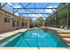 Screened-in pool with an attached jacuzzi surrounded by neutral brick pavers at 2256 Kettle Dr, Orlando, FL 32835