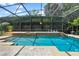 Enclosed pool area with blue water, stone trim, and a mature green privacy hedge at 2256 Kettle Dr, Orlando, FL 32835