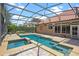 A screened-in pool and integrated hot tub are surrounded by a paved patio at 2256 Kettle Dr, Orlando, FL 32835