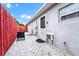 Rear of home with a small patio area, crushed rock ground cover, and a painted fence at 235 Hidden Springs Cir, Kissimmee, FL 34743