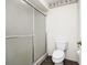 Bathroom features a shower with glass doors, toilet, and palm-themed wallpaper trim at 235 Hidden Springs Cir, Kissimmee, FL 34743