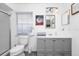 Clean bathroom featuring gray vanity with ample storage, a toilet, and a window at 235 Hidden Springs Cir, Kissimmee, FL 34743