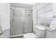 Bright bathroom featuring a glass-enclosed shower, toilet, and large window for natural light at 235 Hidden Springs Cir, Kissimmee, FL 34743