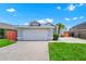 Charming single-story home featuring a well-maintained lawn and a spacious two-car garage at 235 Hidden Springs Cir, Kissimmee, FL 34743