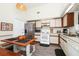Bright kitchen with stainless steel refrigerator, white appliances, and a cozy dining area with a unique light fixture at 235 Hidden Springs Cir, Kissimmee, FL 34743