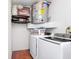 Laundry room boasts washer, dryer, water heater, and storage shelves for maximum utility at 235 Hidden Springs Cir, Kissimmee, FL 34743