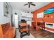Cozy living room with hardwood floors, a ceiling fan, and orange accent wall with a TV at 235 Hidden Springs Cir, Kissimmee, FL 34743