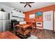 Charming living room with hardwood floors, an orange accent wall, and functional furniture at 235 Hidden Springs Cir, Kissimmee, FL 34743