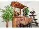 Close-up of a bamboo-style wet bar, two high-top stools, decor, and a view to the kitchen at 235 Hidden Springs Cir, Kissimmee, FL 34743