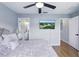 Bright bedroom with ceiling fan and TV, with an ensuite bathroom and wood laminate flooring at 255 Cordova Ave, Davenport, FL 33897