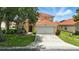 Beautiful home featuring mature trees, a two-car garage, and a vibrant, well-maintained lawn at 255 Cordova Ave, Davenport, FL 33897