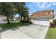 Charming two-story home with tile roof, two-car garage, landscaped yard and concrete driveway on a sunny day at 255 Cordova Ave, Davenport, FL 33897