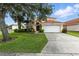 Well-maintained, two-story home featuring a terracotta tile roof, two car garage, and mature landscaping at 255 Cordova Ave, Davenport, FL 33897