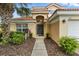 Inviting home exterior featuring a well-manicured lawn, mature landscaping, and a covered front entry at 255 Cordova Ave, Davenport, FL 33897