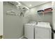 Bright laundry room featuring a white washer and dryer with wire shelving for storage at 255 Cordova Ave, Davenport, FL 33897