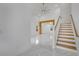 Bright foyer with white marble floors, wood-trimmed stairs, and a view to the living space at 2556 Volta Cir, Kissimmee, FL 34746