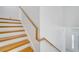 Bright staircase featuring hardwood steps, white risers, and a sleek wooden handrail at 2556 Volta Cir, Kissimmee, FL 34746