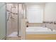 Bathroom with a walk-in shower, tub, and tile accents at 2613 Breezy Meadow Rd, Apopka, FL 32712