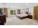 Spacious carpeted primary bedroom featuring a view of a window and bedside tables with lamps at 2613 Breezy Meadow Rd, Apopka, FL 32712