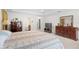 Spacious carpeted primary bedroom featuring an ensuite bathroom and dresser at 2613 Breezy Meadow Rd, Apopka, FL 32712