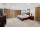 Spacious carpeted primary bedroom featuring a tray ceiling, artwork, and bedside tables with lamps at 2613 Breezy Meadow Rd, Apopka, FL 32712