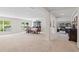Open floor plan combines living & dining area with neutral carpet, natural light, and dark wood furniture at 2613 Breezy Meadow Rd, Apopka, FL 32712