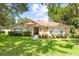 Inviting single-story home with a well-maintained lawn, mature trees, and manicured landscaping at 2613 Breezy Meadow Rd, Apopka, FL 32712