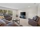 Inviting living room featuring leather seating, a large TV, and a bright window at 2613 Breezy Meadow Rd, Apopka, FL 32712