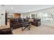 Spacious living room with leather seating and a large window, seamlessly connected to the kitchen at 2613 Breezy Meadow Rd, Apopka, FL 32712