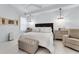 Comfortable bedroom with white linens, two chandeliers, and herringbone patterned furniture at 2781 Stanfield Ave, Orlando, FL 32814