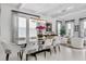 Elegant dining area featuring a modern chandelier, glass table, and white chairs at 2781 Stanfield Ave, Orlando, FL 32814