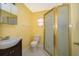 Full yellow bathroom with a glass shower, sink, toilet and vanity at 2918 E Central Blvd, Orlando, FL 32803