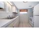 White kitchen featuring stainless steel sink, tile floors and updated appliances at 2918 E Central Blvd, Orlando, FL 32803