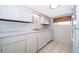 White kitchen features updated appliances, tile floor, and light countertops at 2918 E Central Blvd, Orlando, FL 32803