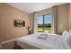 Cozy bedroom featuring a plush bed, modern decor, and a view of the outside at 3056 Rockefeller Way, Kissimmee, FL 34747