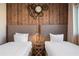 Warm bedroom featuring two beds, side table with industrial style with a wood accent wall and clock detail at 3056 Rockefeller Way, Kissimmee, FL 34747