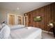 Bright bedroom with two beds, rustic wood accent wall, flatscreen TV, and en suite bathroom and closet at 3056 Rockefeller Way, Kissimmee, FL 34747