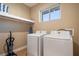 Efficient laundry room with modern washer and dryer and ample shelving at 3056 Rockefeller Way, Kissimmee, FL 34747