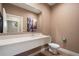 Stylish powder room with a modern floating vanity, large mirror, and artistic decor at 3056 Rockefeller Way, Kissimmee, FL 34747