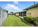 Lush backyard with manicured lawn and a partial view of the building's screened-in patio at 3280 Villa Way Cir, St Cloud, FL 34769