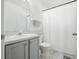 Bright bathroom featuring a single sink vanity, toilet, and a shower with a white curtain at 3280 Villa Way Cir, St Cloud, FL 34769