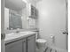 Neat bathroom with a single sink vanity, a mirrored cabinet, a toilet, and a shower with glass doors at 3280 Villa Way Cir, St Cloud, FL 34769