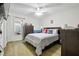 Cozy bedroom with hardwood floors, a ceiling fan, a bed with a decorative quilt, and a window at 3280 Villa Way Cir, St Cloud, FL 34769
